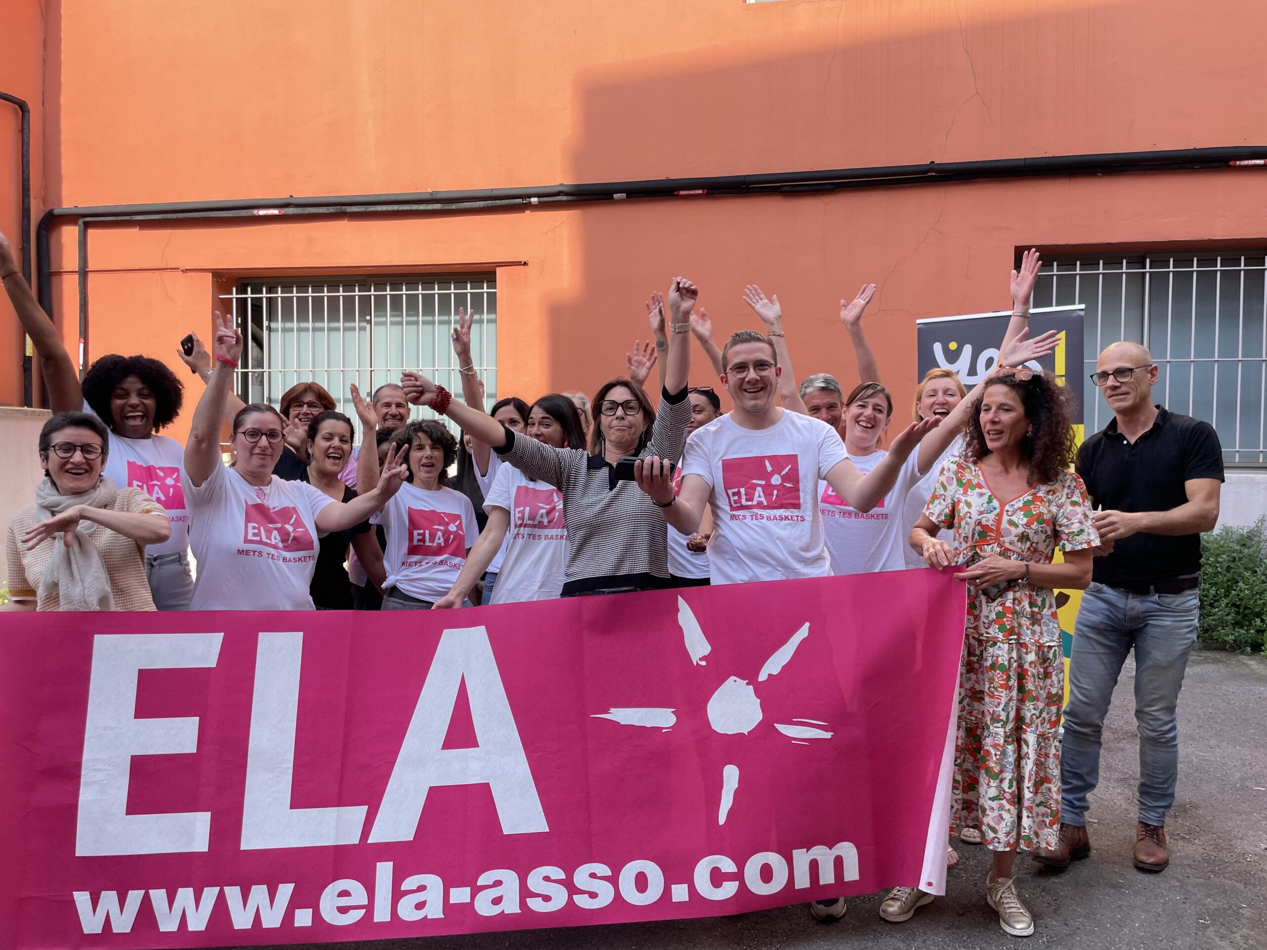 Les salariés Yes ! posent devant une banderole de l'association ELA